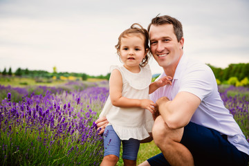 Fototapeta premium Happy family father and daughter having fun in lavender field