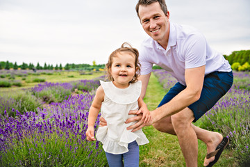 Fototapeta premium Happy family father and daughter having fun in lavender field