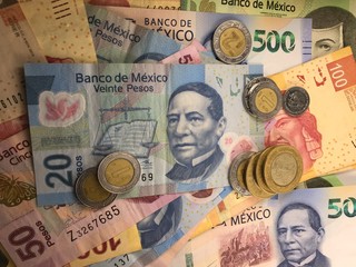 Mexican peso bills spread randomly over a flat surface