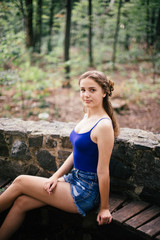 Beautiful girl in short shorts and a blue T-shirt in the woods