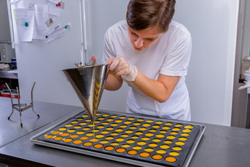 Pastry chef in the kitchen makes passion fruit confit. Cook pours passion fruit confit into the molds. Master class in the kitchen. The process of cooking. Step by step. Tutorial. Close-up