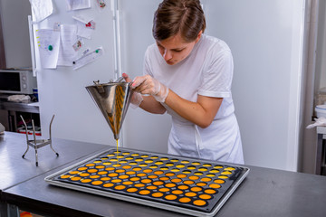 Pastry chef in the kitchen makes passion fruit confit. Cook pours passion fruit confit into the molds. Master class in the kitchen. The process of cooking. Step by step. Tutorial. Close-up