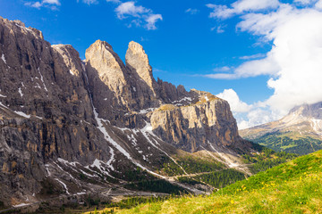 Fototapeta na wymiar colorful top view to Sassolungo mountain in the clouds on a Sunny summer day from Passo Sella di val Gardena Dolomites, South Tyrol, alto adige, Italy. Langkofel in the Dolomiti Alps above Pass Pordoi