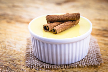 Brazilian sweet cream-like dessert cured corn mousse with cinnamon. Corn porridge with cinnamon in a bowl. Typical green corn foods tasty and cheap typical and popular street food