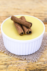 Brazilian sweet cream-like dessert cured corn mousse with cinnamon. Corn porridge with cinnamon in a bowl. Typical green corn foods tasty and cheap typical and popular street food