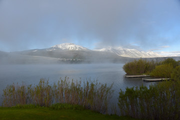 fog coming off lake early in the morning with snowing mountain in background