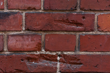 Red bright brick wall background. Large tiles. Textured wallpaper. Close up.