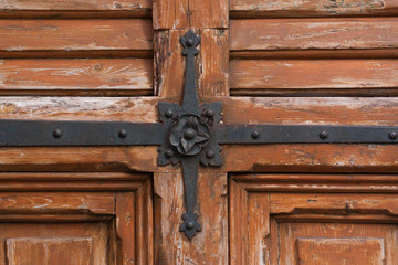 Old city worn out wooden  doorw with black metal rose  decoration. Textured backgrounds.