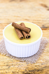 Dessert of curau. Brazilian sweet corn, corn mousse with cinnamon on a wooden background. Typical Brazilian dessert, sweet of June party. Dessert, canjica or Jimbelê.