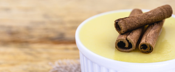 Brazilian sweet cream-like dessert cured corn mousse with cinnamon. Corn porridge with cinnamon in a bowl. Typical green corn foods tasty and cheap typical and popular street food