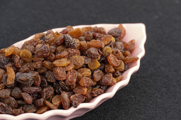 yellow seedless raisins on a plate, close-up