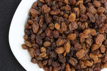 yellow seedless raisins on a plate, close-up