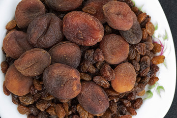 close-up of yellow seedless raisins and day dried apricots, on a plate