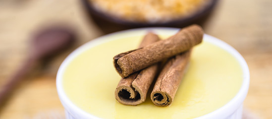 Dessert of curau. Brazilian sweet corn, corn mousse with cinnamon on a wooden background. Typical Brazilian dessert, sweet of June party. Dessert, canjica or Jimbelê.