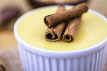 Dessert of curau. Brazilian sweet corn, corn mousse with cinnamon on a wooden background. Typical Brazilian dessert, sweet of June party. Dessert, canjica or Jimbelê.