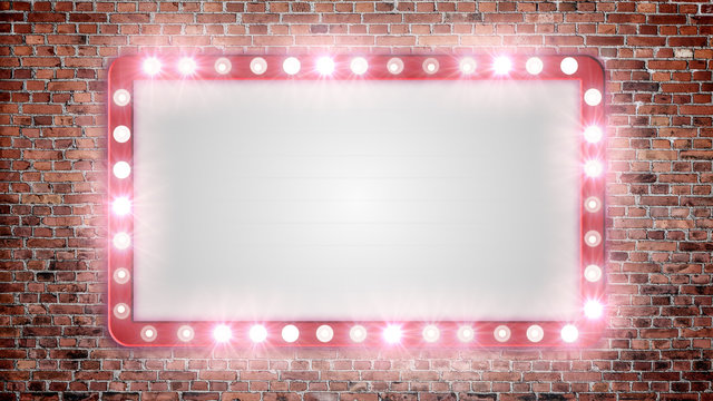 A blank marquee sign on a red brick wall with flashing lights.	