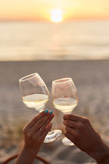 Couple clinking glasses of champagne at sunset
