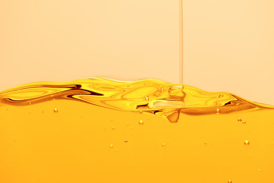 Yellow Bright Liquid Stream With Bubbles Isolated On Yellow