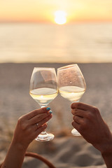 Couple clinking glasses of champagne at sunset