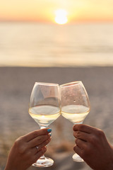 Couple clinking glasses of champagne at sunset