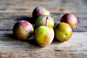 Plums in the garden in the morning, on old boards.