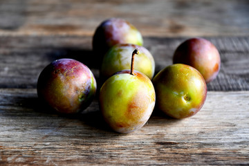 Plums in the garden in the morning, on old boards.