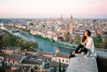 Young woman enjoying beautiful view on Verona city in Italy in the morning. Famous italian...