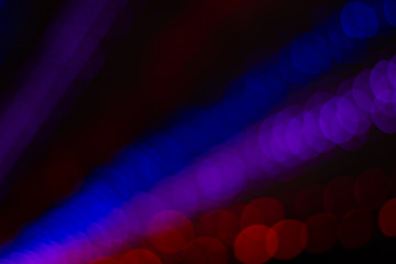 night unfocused pink blue and red bokeh ray of light illumination from some event decoration garland lamps in darkness 