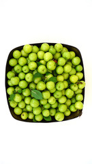 green plums, fresh plums, sour plums in a container, green and sour plums close-up,