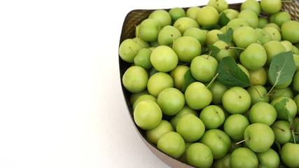 lots of green and sour fresh plums, on white background