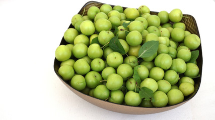 lots of green and sour fresh plums, on white background