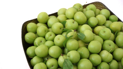 green plums on white ground, fresh plums, 