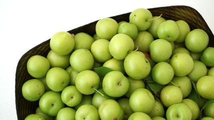green plums on white ground, fresh plums, 