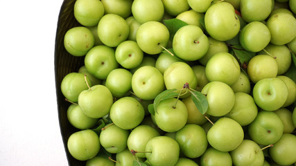 green plums on white ground, fresh plums, 