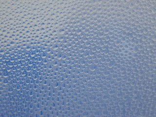 Water droplets surface on clear glass  In blue and white tones