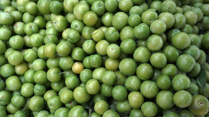 sour green plums in close-up bench, 