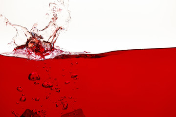 red bright liquid with splash and bubbles isolated on white