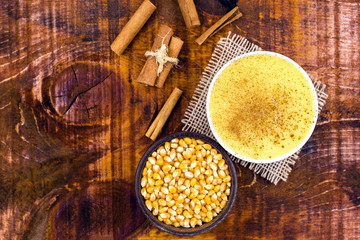 Dessert of curau. Brazilian sweet corn, corn mousse with cinnamon on a wooden background. Typical Brazilian dessert, sweet of June party. Dessert, canjica or Jimbelê.