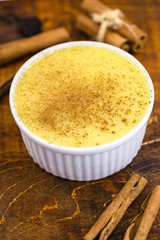 Brazilian sweet corn, corn mousse on a wooden background with copy space. Typical Brazilian dessert, sweet of mingua, called in Brazil of curau. Typical sweet of June party.