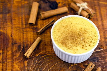 Brazilian sweet corn, corn mousse on a wooden background with copy space. Typical Brazilian dessert, sweet of mingua, called in Brazil of curau. Typical sweet of June party.