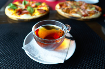 Tea cup with pizza on black table