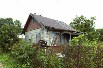Abandoned rural house with birds on the roof