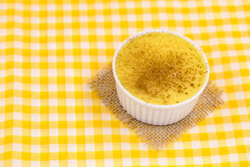 Dessert of curau. Brazilian sweet corn, corn mousse with cinnamon on a wooden background. Typical Brazilian dessert, sweet of June party. Dessert, canjica or Jimbelê.