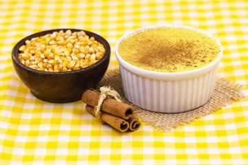 Brazilian sweet corn cream, Dessert, canjica or Jimbelê, dessert cured corn corn mousse with cinnamon on a wood background. Copy space