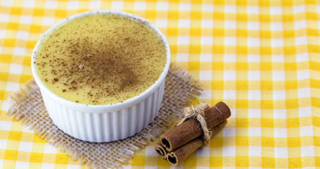 Brazilian sweet corn cream, Dessert, canjica or Jimbelê, dessert cured corn corn mousse with cinnamon on a wood background. Copy space