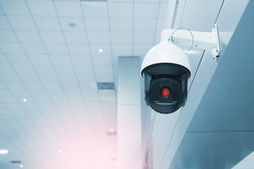 Modern CCTV camera on a wall. A blurred night cityscape background. Concept of surveillance and...