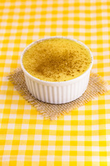 Brazilian sweet corn cream, Dessert, canjica or Jimbelê, dessert cured corn corn mousse with cinnamon on a wood background. Copy space