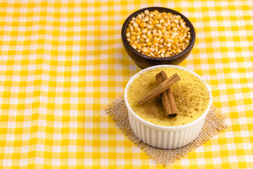 Brazilian sweet corn cream, Dessert, canjica or Jimbelê, dessert cured corn corn mousse with cinnamon on a wood background. Copy space
