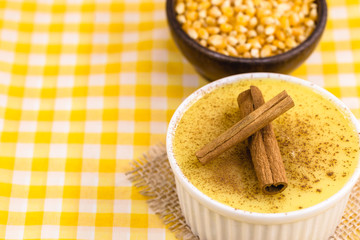 Dessert of curau. Brazilian sweet corn, corn mousse with cinnamon on a wooden background. Typical Brazilian dessert, sweet of June party. Dessert, canjica or Jimbelê.