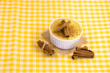 Dessert of curau. Brazilian sweet corn, corn mousse with cinnamon on a wooden background. Typical Brazilian dessert, sweet of June party. Dessert, canjica or Jimbelê.